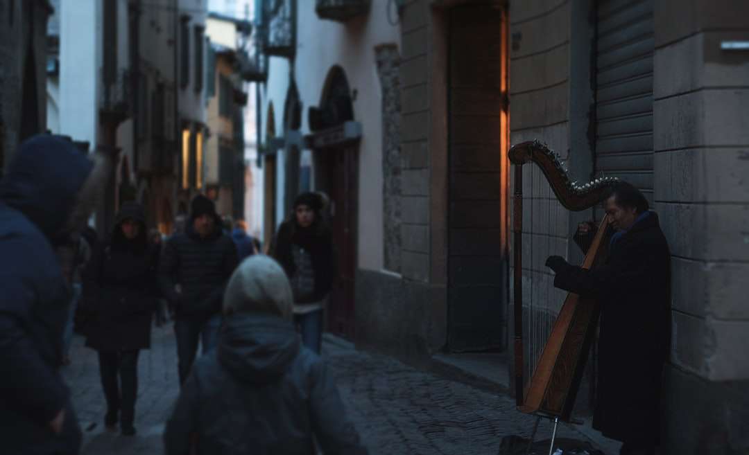 mężczyzna gra na instrumencie muzycznym w pobliżu brązowy mur puzzle online