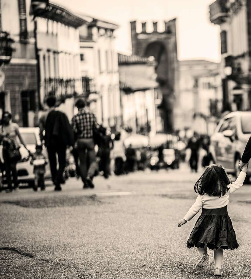 fotografia w skali szarości przedstawiająca dziecko spacerujące po chodniku puzzle online