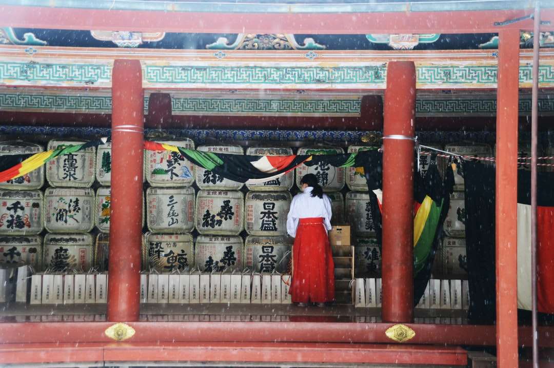 жінка в білій сукні, стоячи на червоні дерев'яні двері головоломка