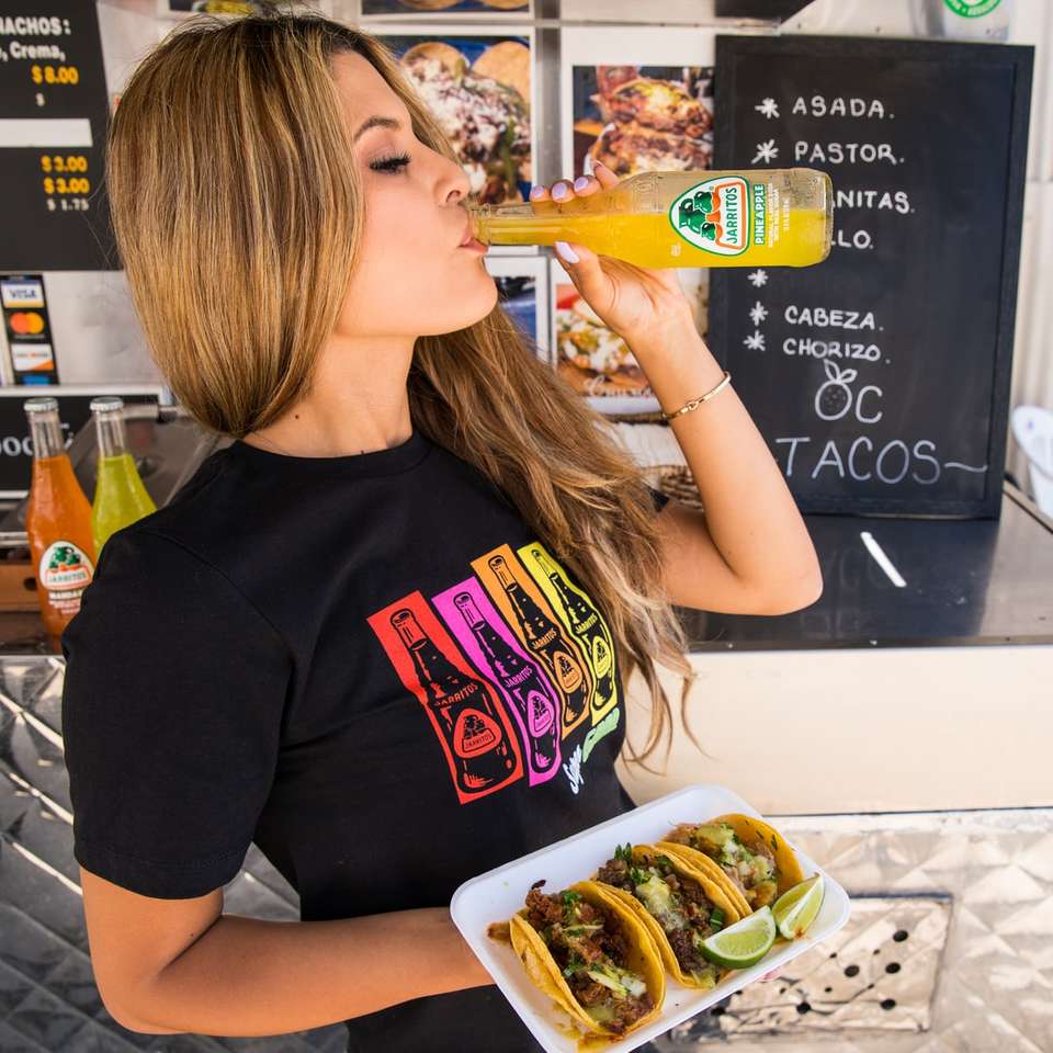 kobieta w czarnej koszulce z okrągłym dekoltem, jedzenie burgera puzzle online