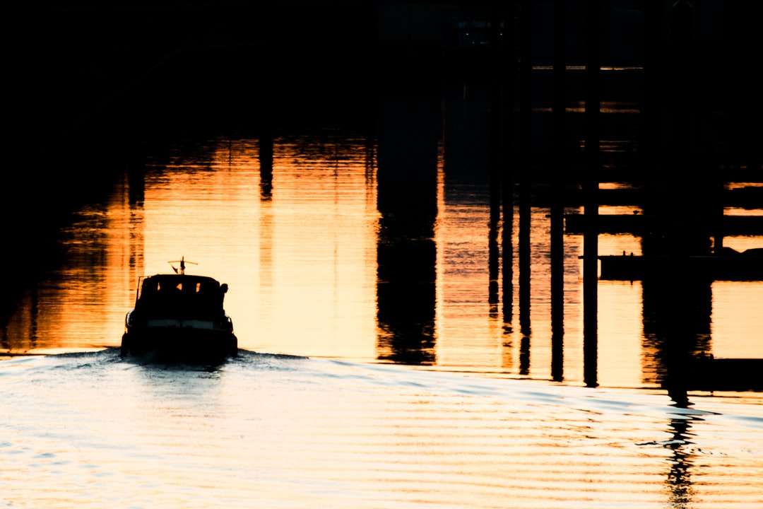 silhuett av båt på vatten under solnedgången pussel