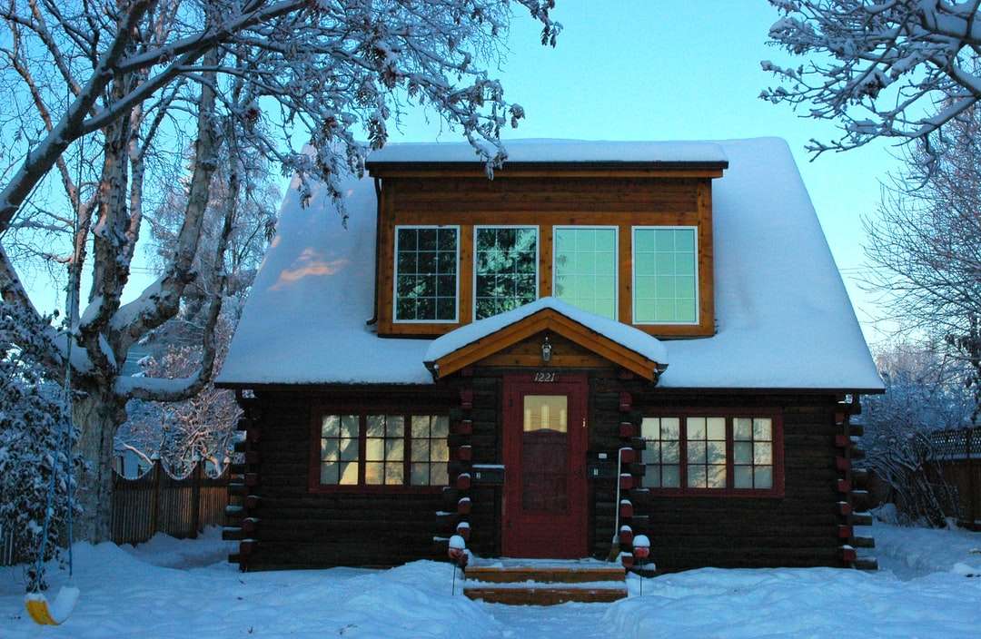brązowy drewniany dom pokryty śniegiem w ciągu dnia puzzle online