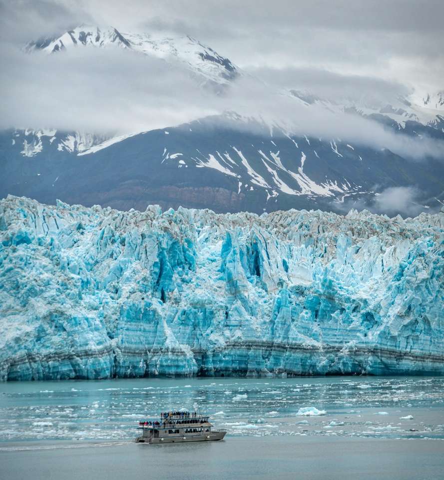 biała łódź na zbiorniku wodnym w pobliżu góry pokryte śniegiem puzzle online