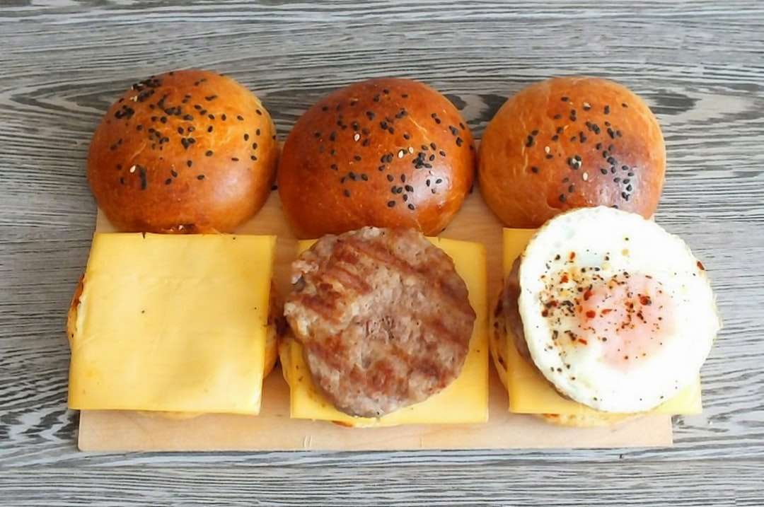 dwa burgery z serem i jajkiem na białym talerzu ceramicznym puzzle online