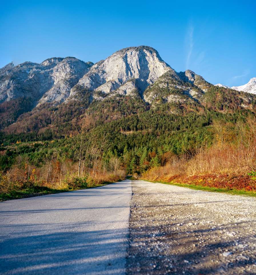 szara droga asfaltowa między zielonym polem trawy w pobliżu góry puzzle online