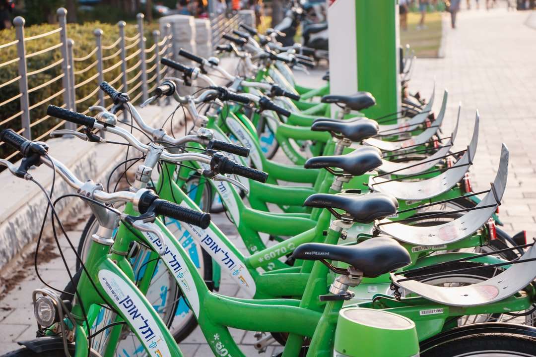 zielona partia rowerów na szarym stalowym płocie w ciągu dnia puzzle online