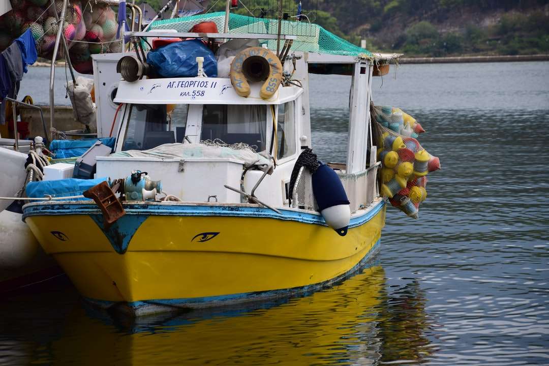 żółto-niebieska łódź na wodzie w ciągu dnia puzzle online