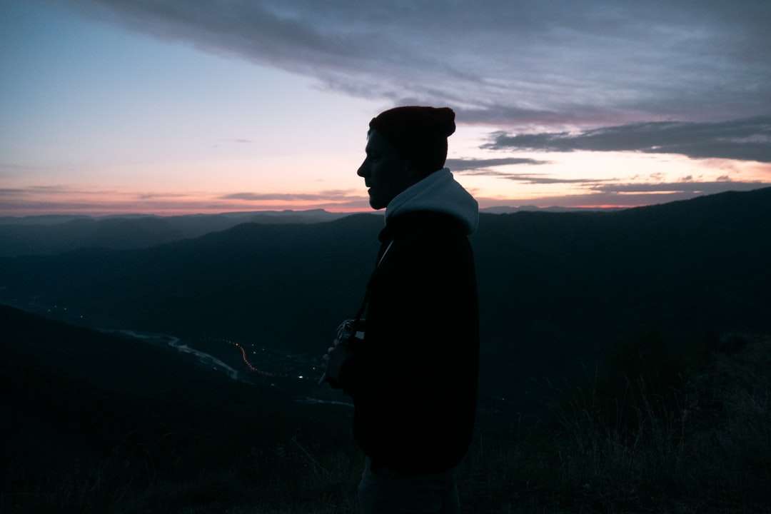 sylwetka człowieka stojącego na górze podczas zachodu słońca puzzle online