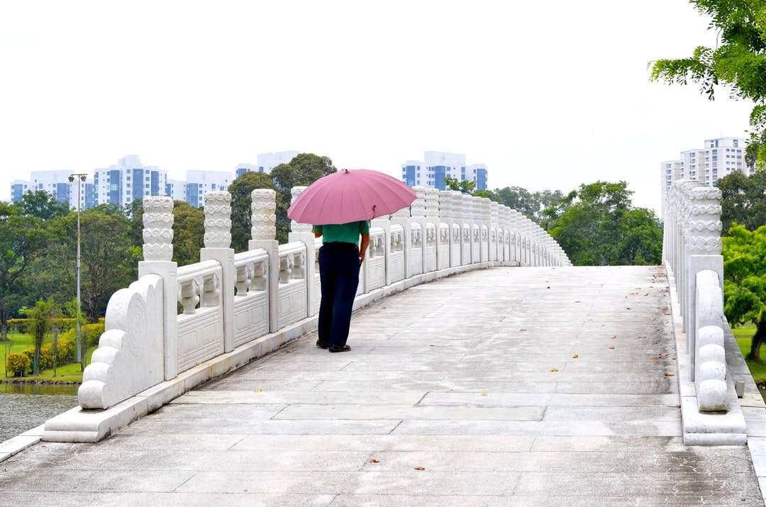 kobieta w czarnych spodniach trzymając różowy parasol puzzle online