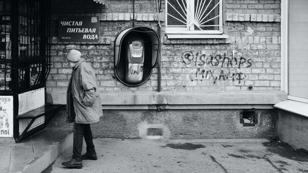 mężczyzna w szarej kurtce stojący w pobliżu ściany z graffiti puzzle online