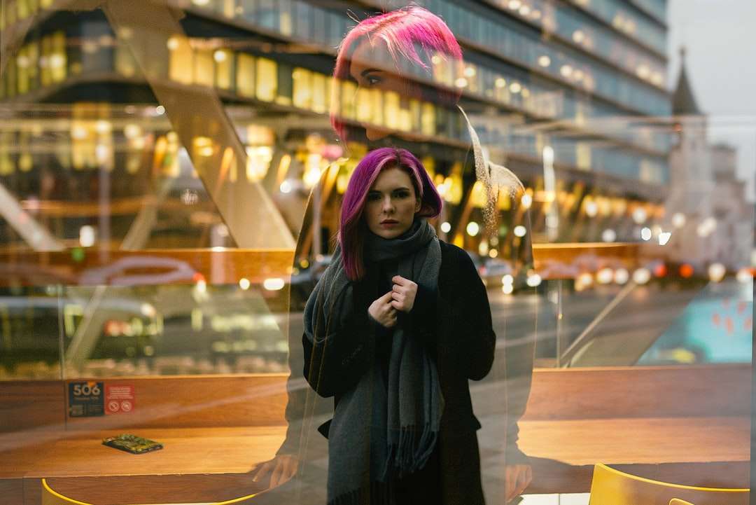 kobieta w czarnym płaszczu stojąca w pobliżu szklanej ściany puzzle online