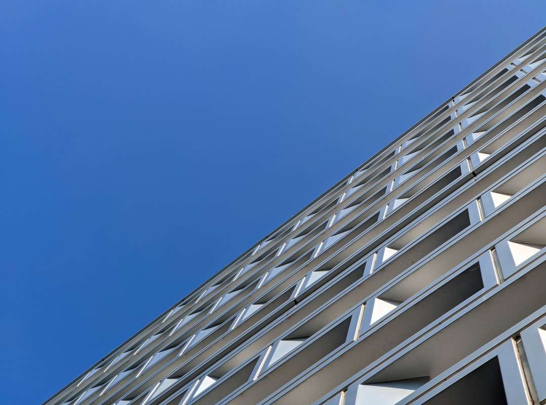 biały betonowy budynek pod błękitnym niebem w ciągu dnia puzzle online