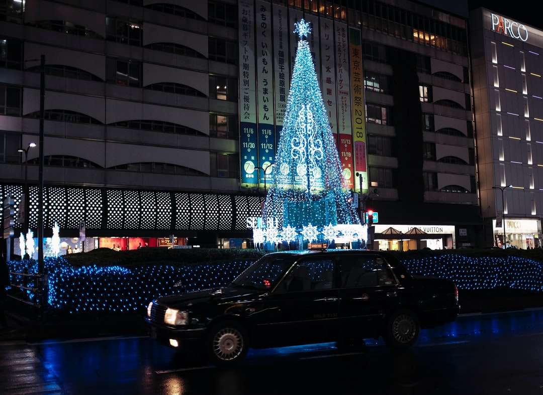 czarny sedan zaparkowany w pobliżu oświetlonej choinki puzzle online