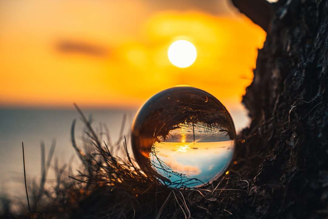 przezroczysta szklana kula na brązowej trawie podczas zachodu słońca puzzle online