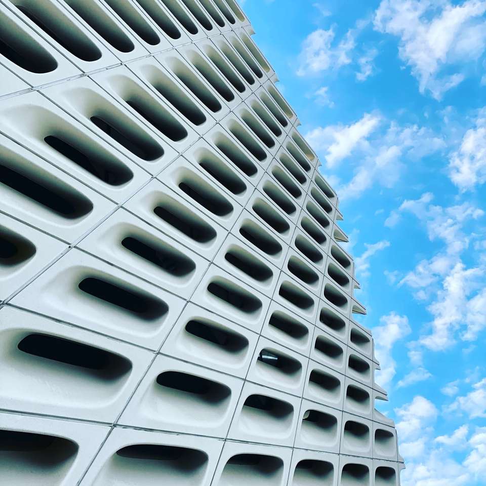 biały betonowy budynek pod błękitne niebo w ciągu dnia puzzle online
