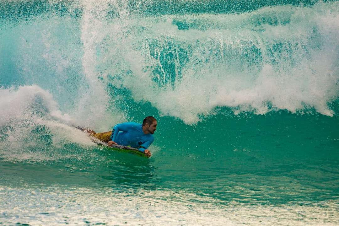 muž v modré košili, surfování na mořských vlnách během dne puzzle