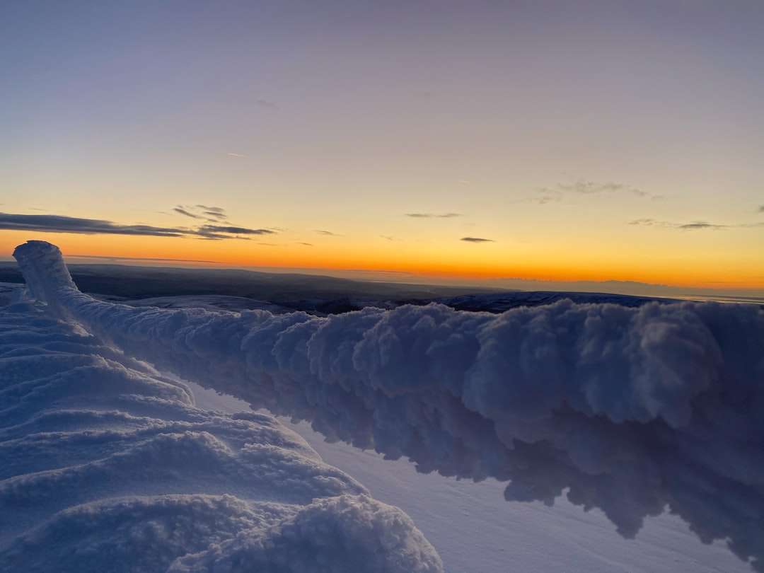 pokryta śniegiem ziemia podczas zachodu słońca puzzle online