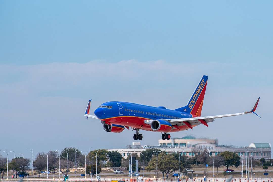 czerwony i biały samolot na lotnisku w ciągu dnia puzzle online