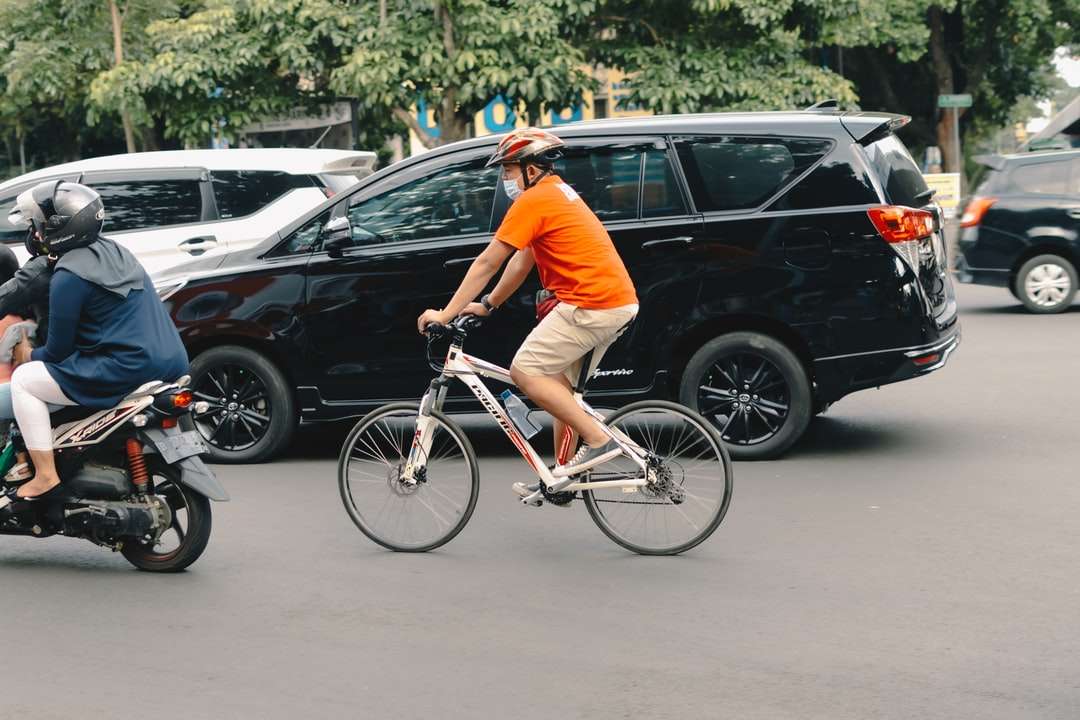 mężczyzna w pomarańczowej koszulce, jazda na białym rowerze puzzle online