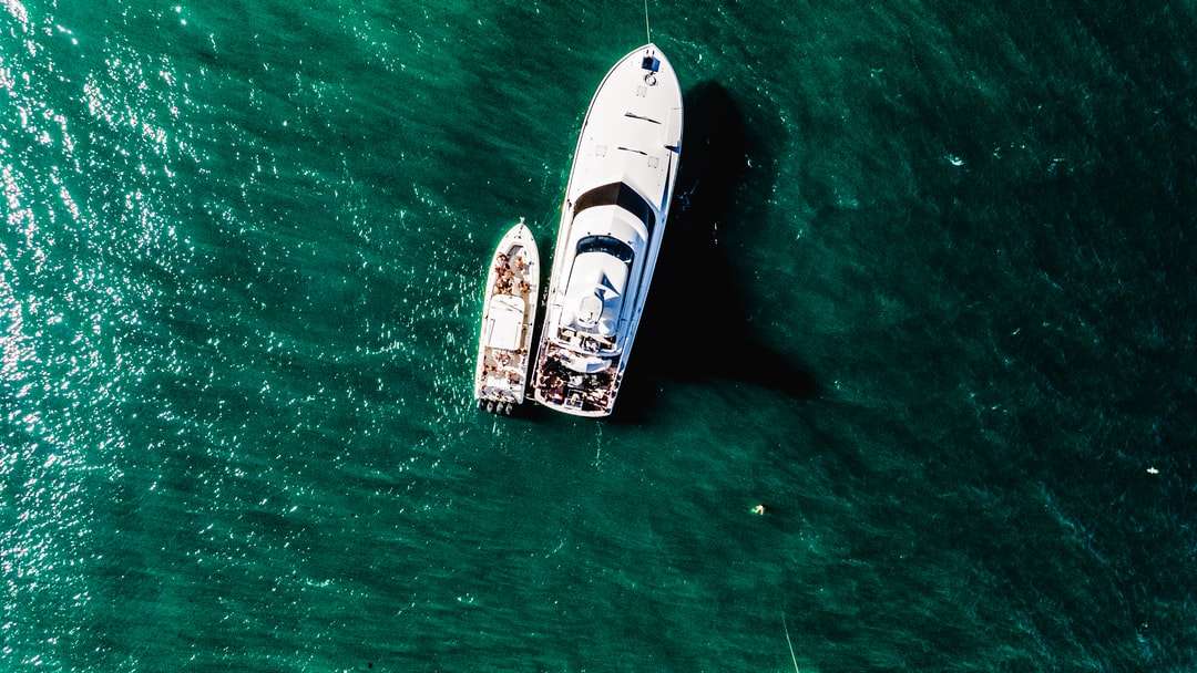 biało-brązowa łódź na zielonym morzu w ciągu dnia puzzle online