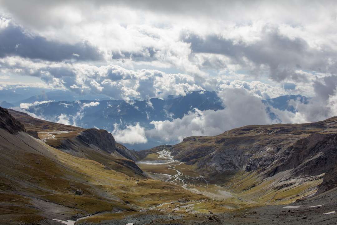 brązowe i zielone góry pod białymi chmurami i błękitnym niebem puzzle online