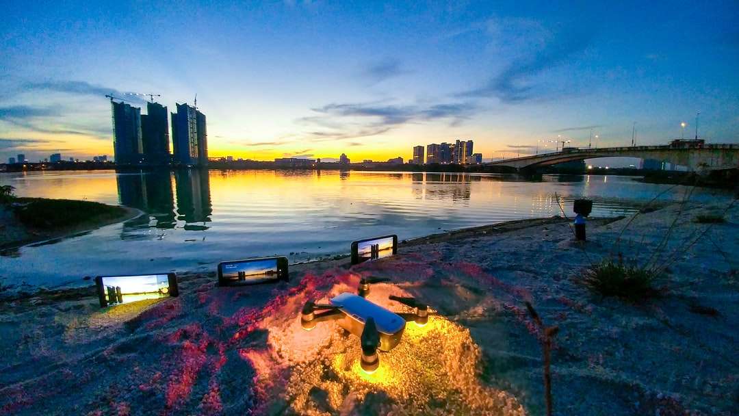 zbiornik wodny w pobliżu mostu i budynków miejskich podczas zachodu słońca puzzle online