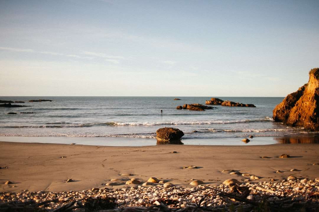 brązowa skała na brzegu morza w ciągu dnia puzzle online