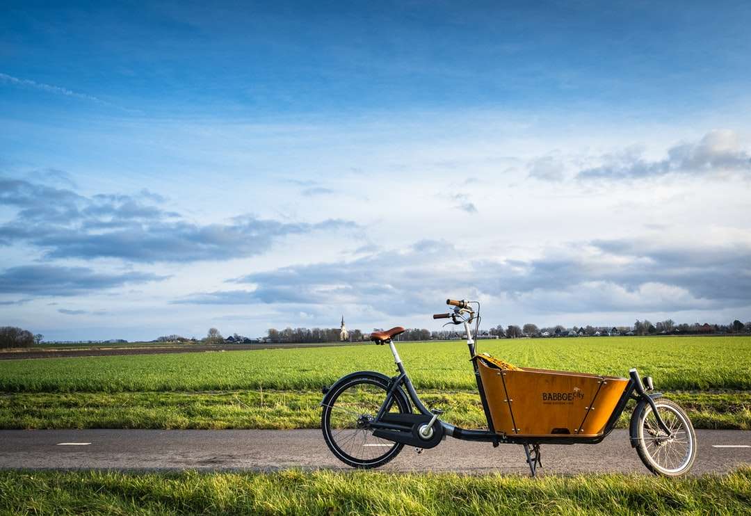 żółty i czarny rower na zielonym polu trawy puzzle online