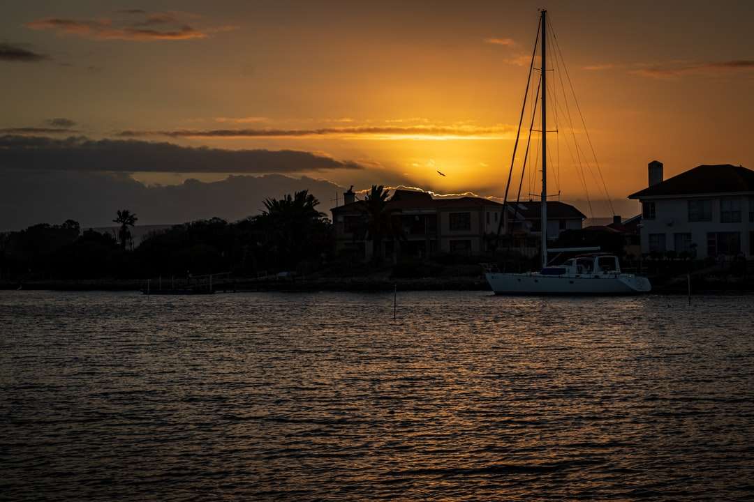 biała łódź na morzu podczas zachodu słońca puzzle online