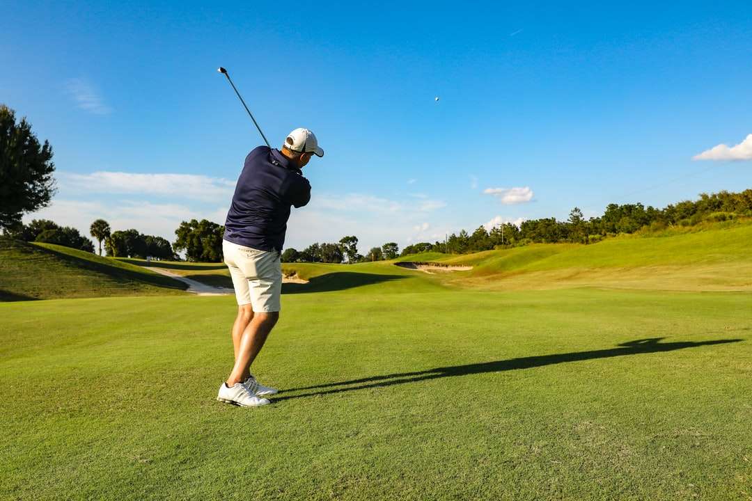 mężczyzna w czarnej koszulce i białych spodenkach, gra w golfa puzzle online
