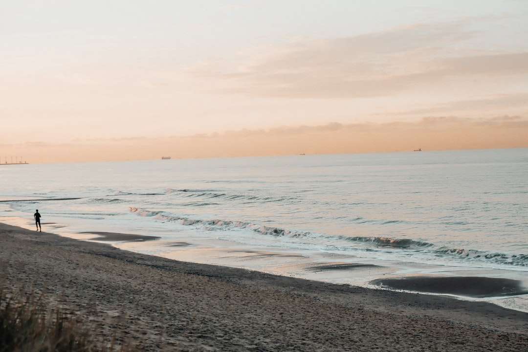 fale morskie rozbijające się o brzeg podczas zachodu słońca puzzle online