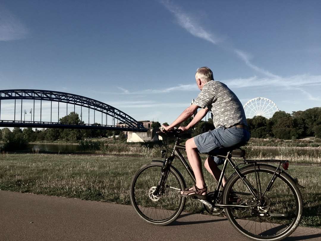 mężczyzna w szaro-białej koszuli w paski, jazda na czarnym rowerze puzzle online