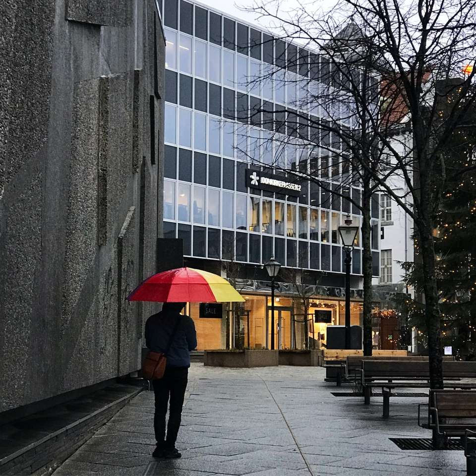 osoba w czarnej kurtce i czarnych spodniach trzyma parasol puzzle online