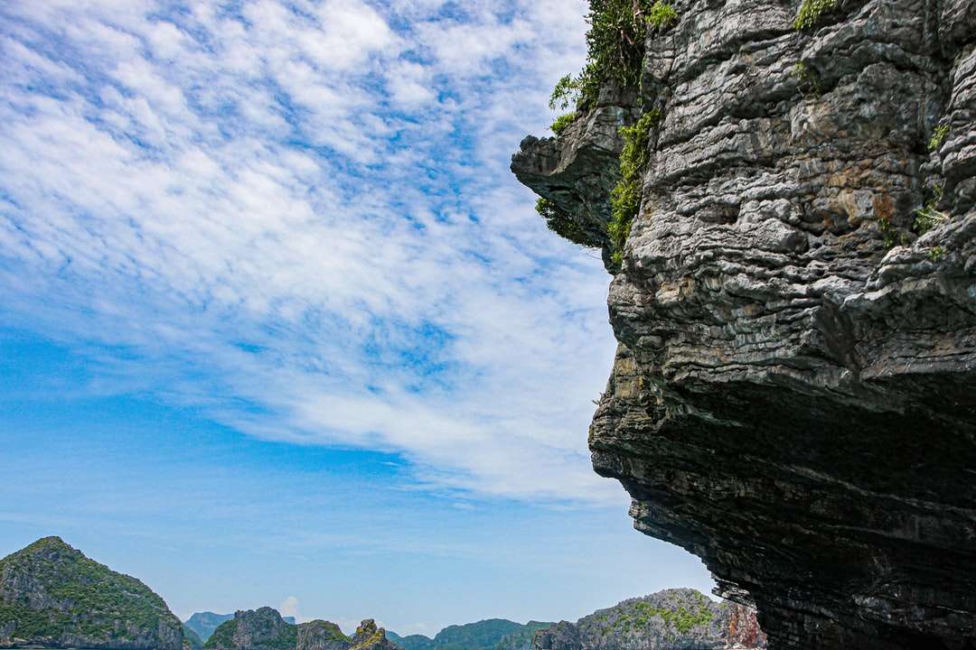 brązowa formacja skalna pod błękitnym niebem i białymi chmurami puzzle online