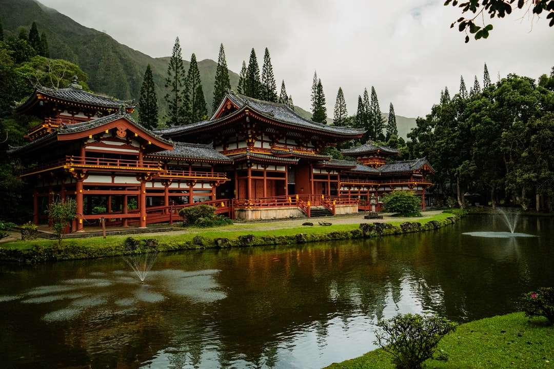 brązowo-czarna świątynia w pobliżu jeziora i zielonych drzew puzzle online