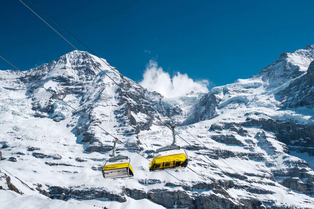 żółty samochód na ziemi pokrytej śniegiem w ciągu dnia puzzle online