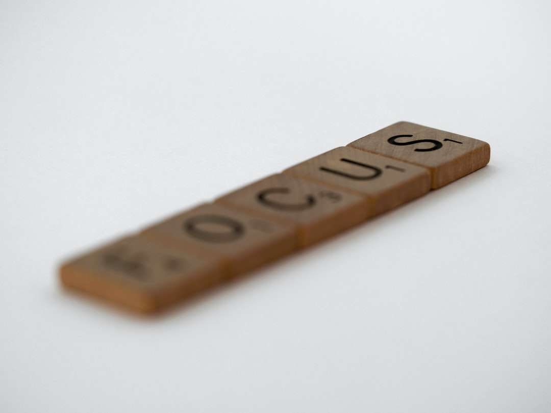 brązowa drewniana litera t-na białej powierzchni puzzle online