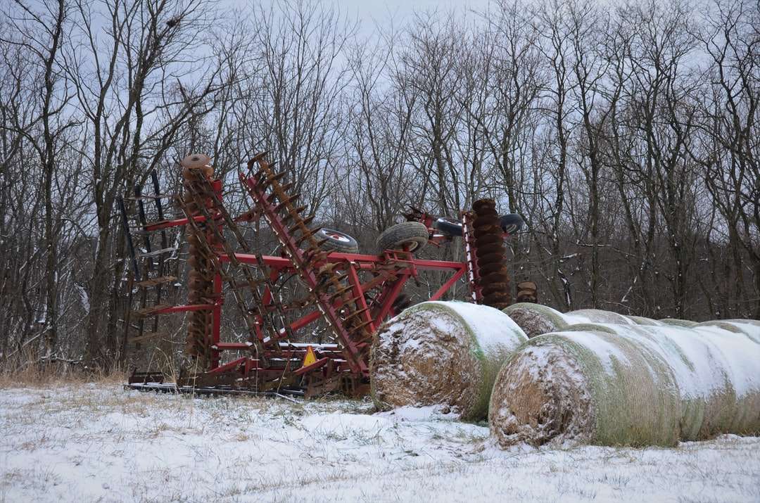 czerwona metalowa maszyna na ziemi pokrytej śniegiem w ciągu dnia puzzle online