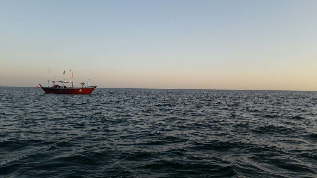 czerwono-biała łódź na morzu w ciągu dnia puzzle online