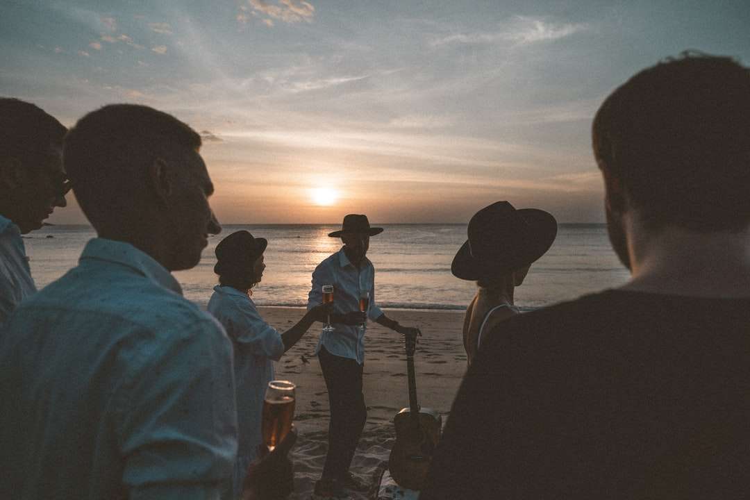 sylwetka ludzi stojących na brzegu morza podczas zachodu słońca puzzle online