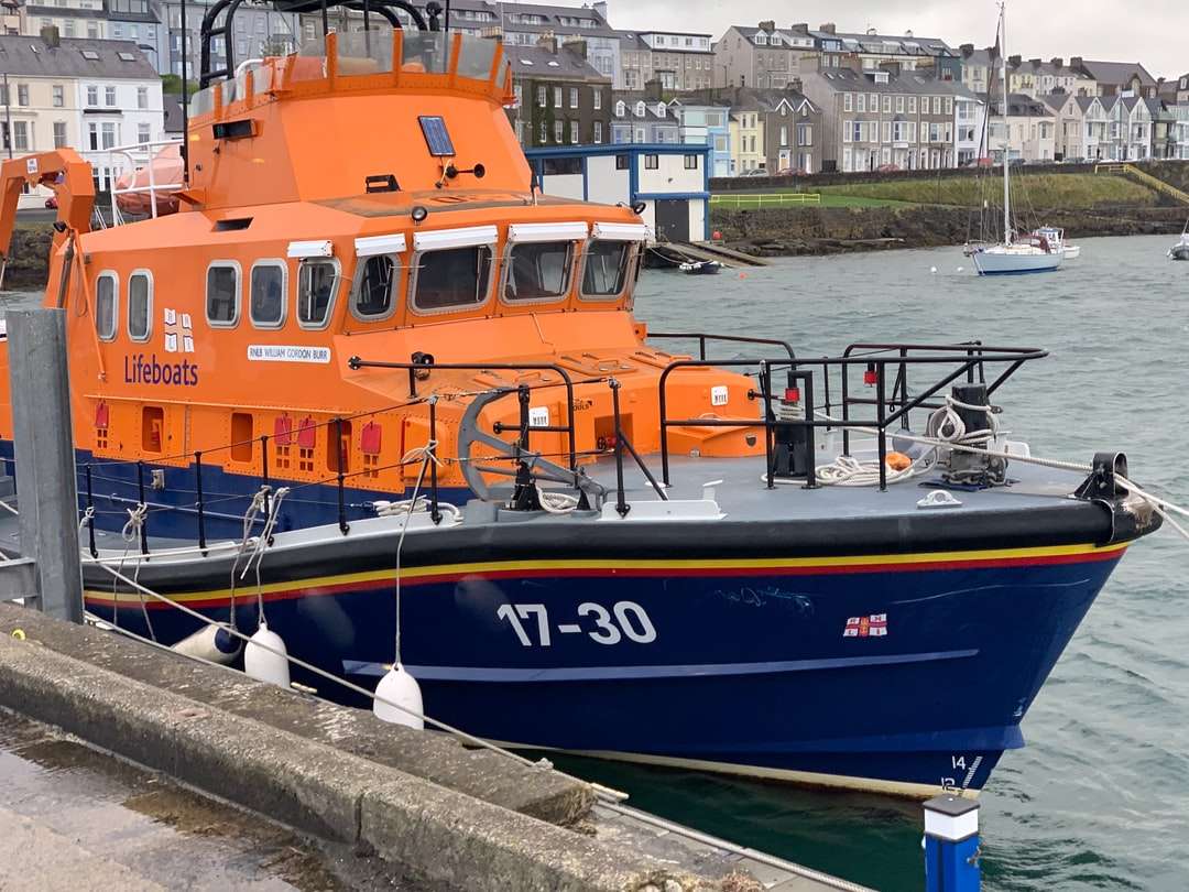 niebieski i pomarańczowy łódź na doku w ciągu dnia puzzle online