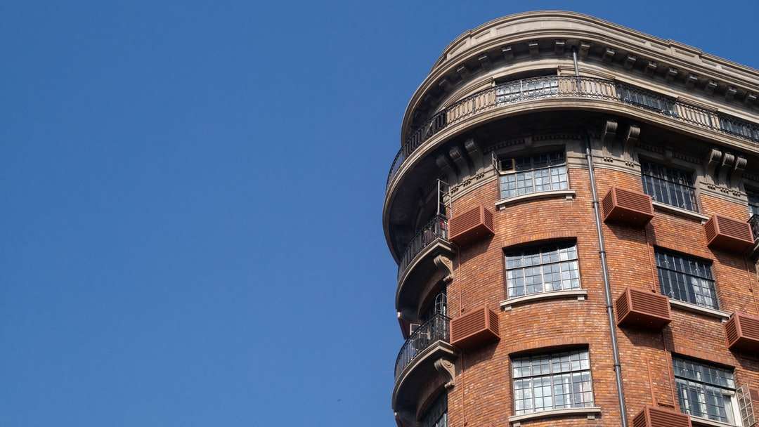 brązowy i czarny betonowy budynek pod błękitnym niebem puzzle online