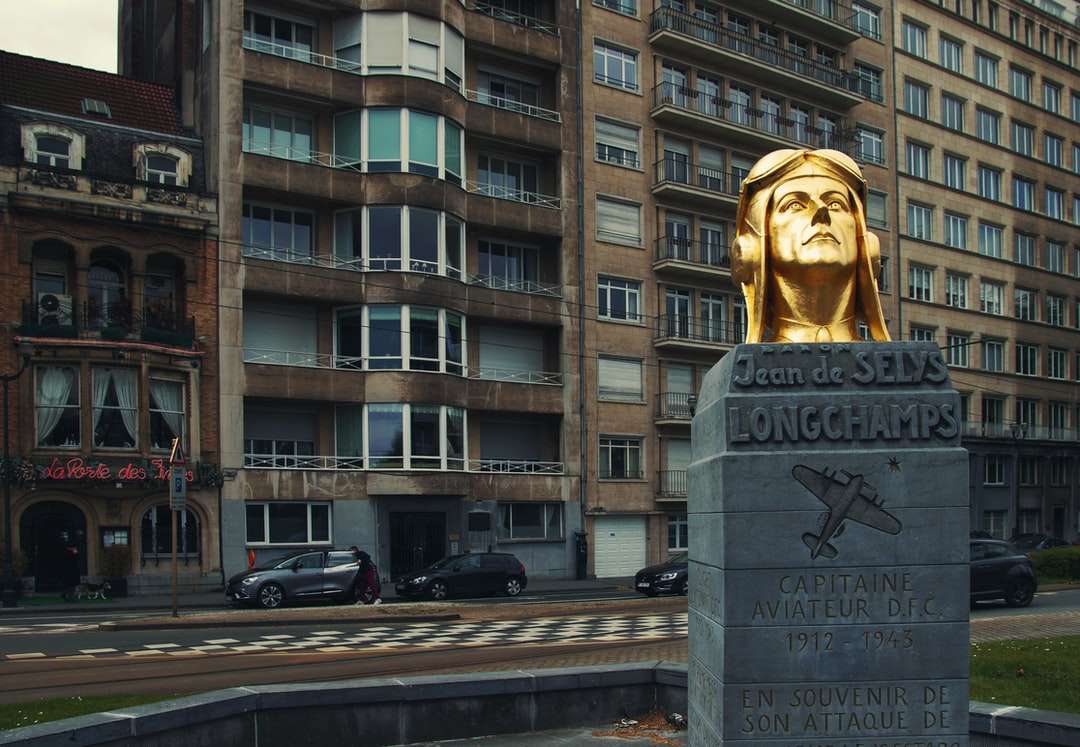szary betonowy posąg w pobliżu brązowego betonowego budynku puzzle online
