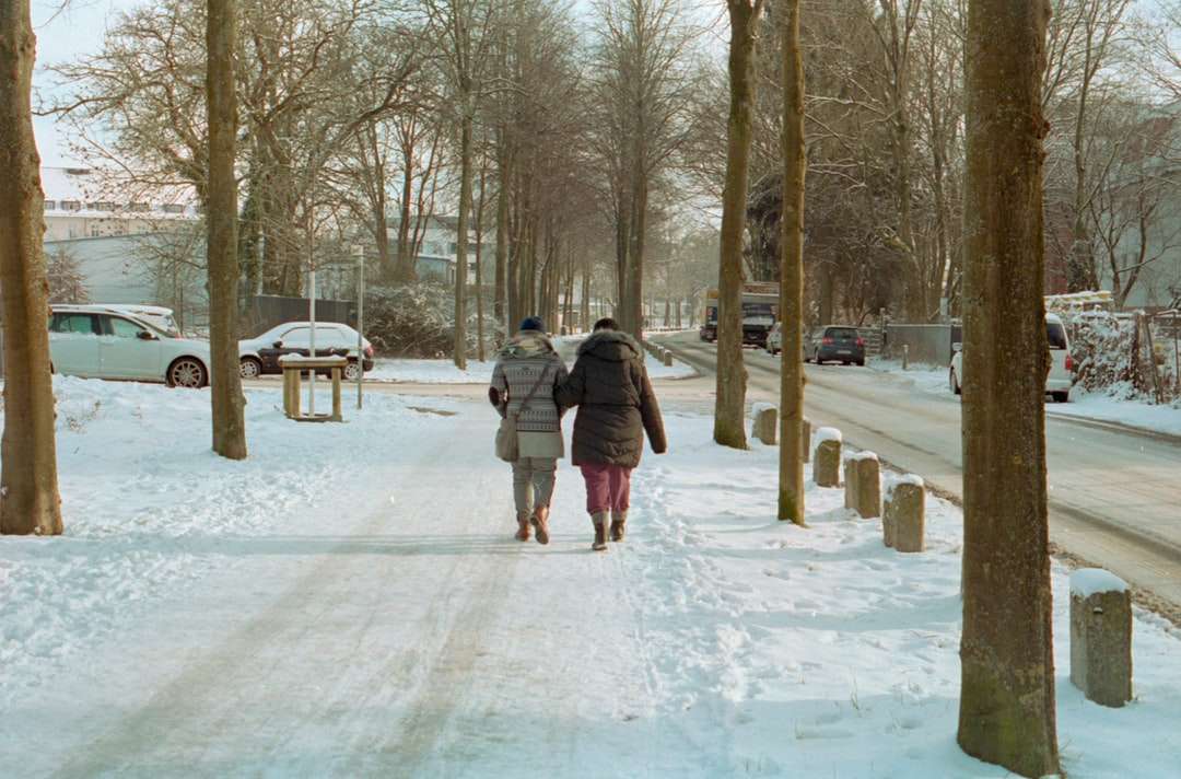 kobieta w szarym płaszczu chodzenie po ziemi pokryte śniegiem puzzle online