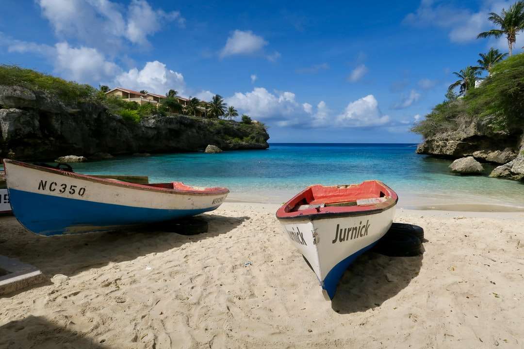 czerwono-biała łódź na plaży w ciągu dnia puzzle online