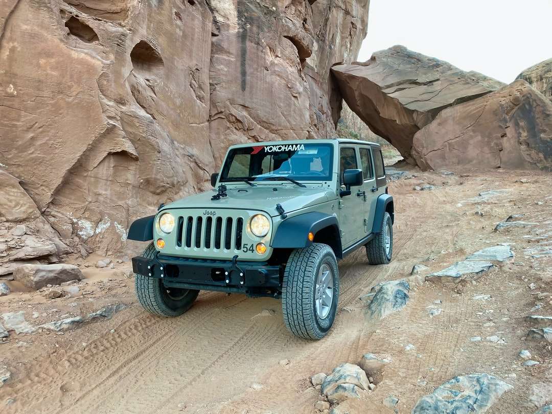 niebieski jeep wrangler na kamienistej drodze w ciągu dnia puzzle online