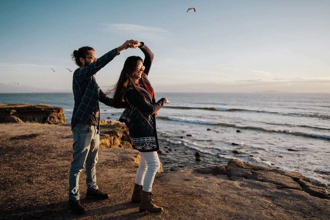 mężczyzna i kobieta stojąc na plaży w ciągu dnia puzzle online