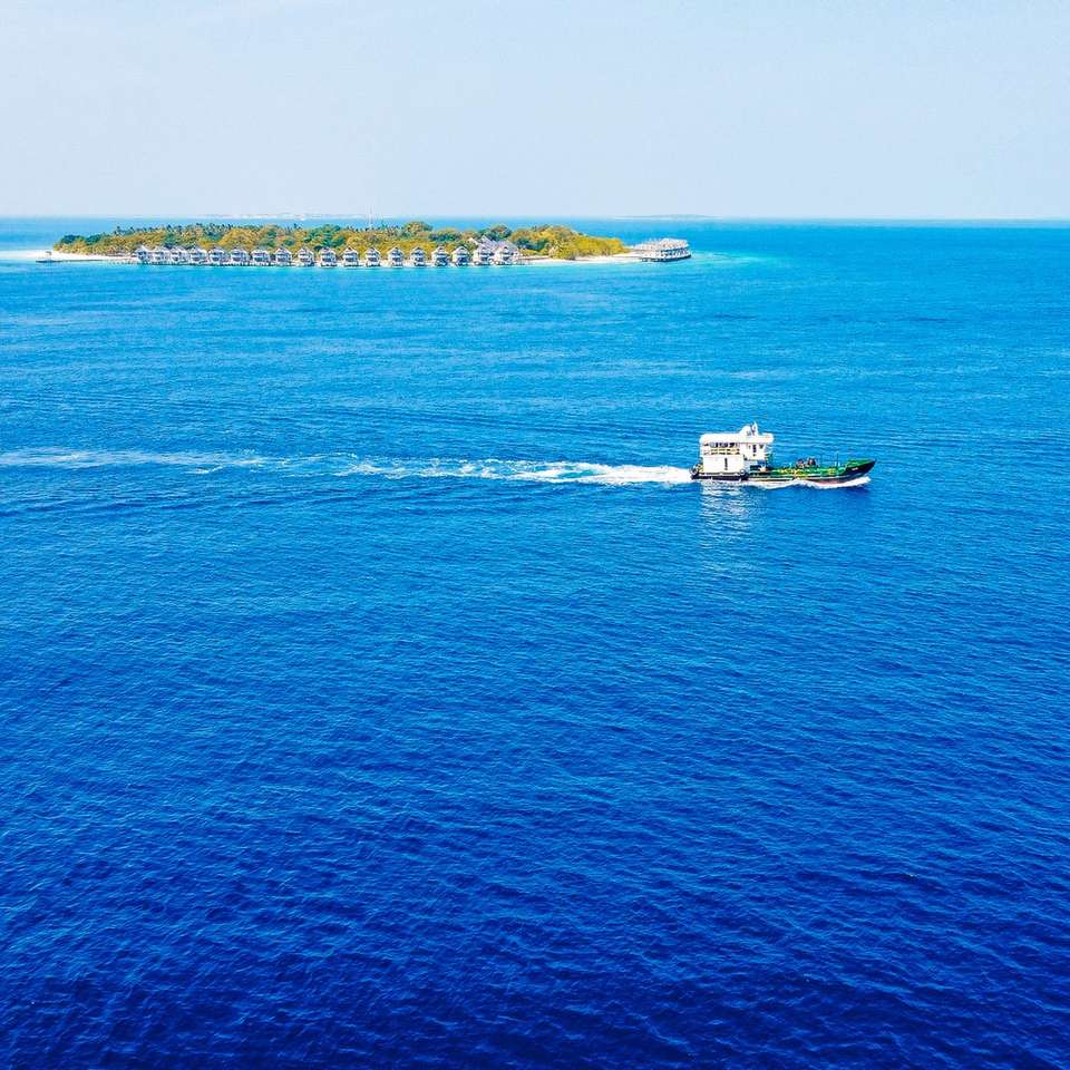 biało-czarna łódź na błękitnym morzu w ciągu dnia puzzle online