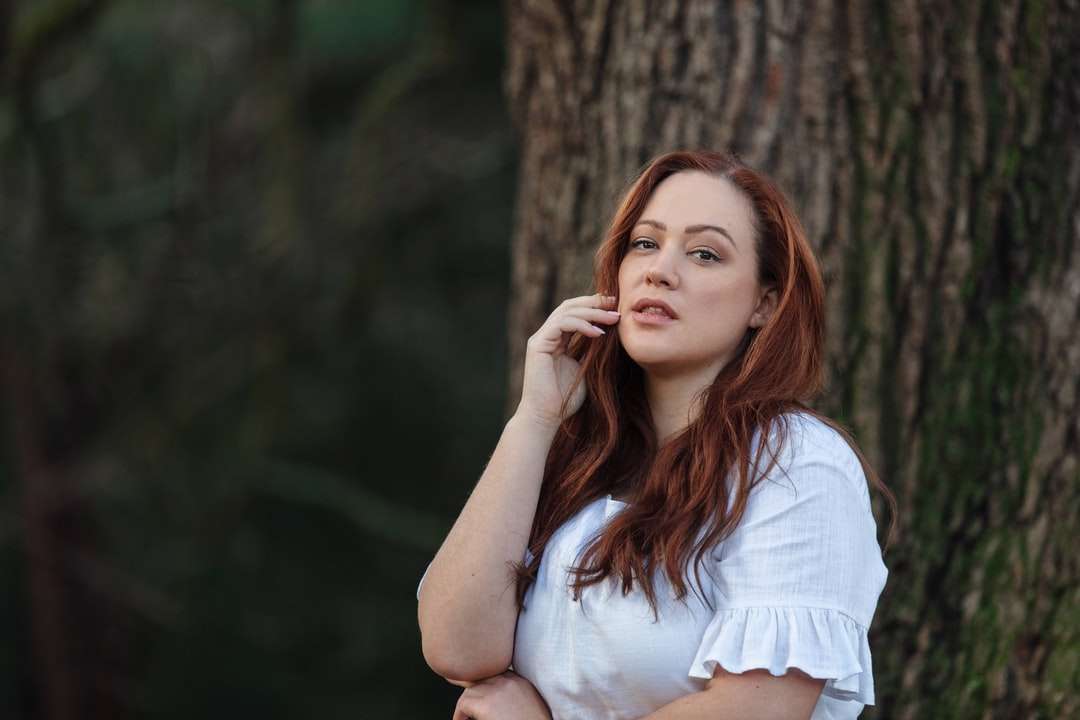 kobieta w białej koszuli, opierając się na brązowym drzewie puzzle online