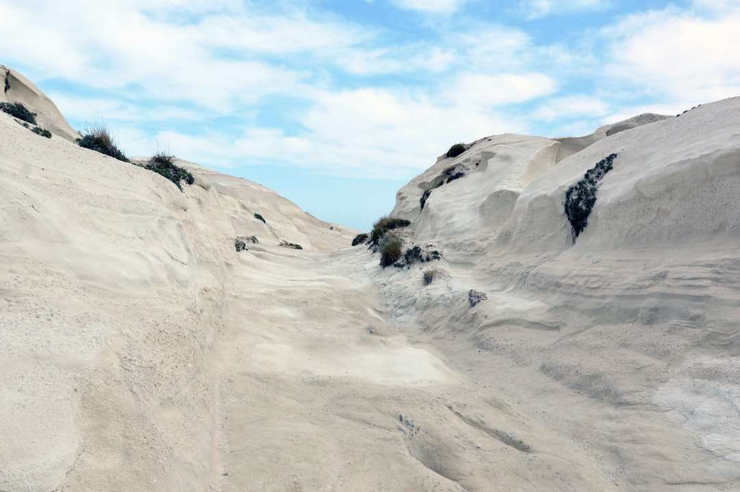 osoba stojąca na białe pokryte śniegiem góry puzzle online
